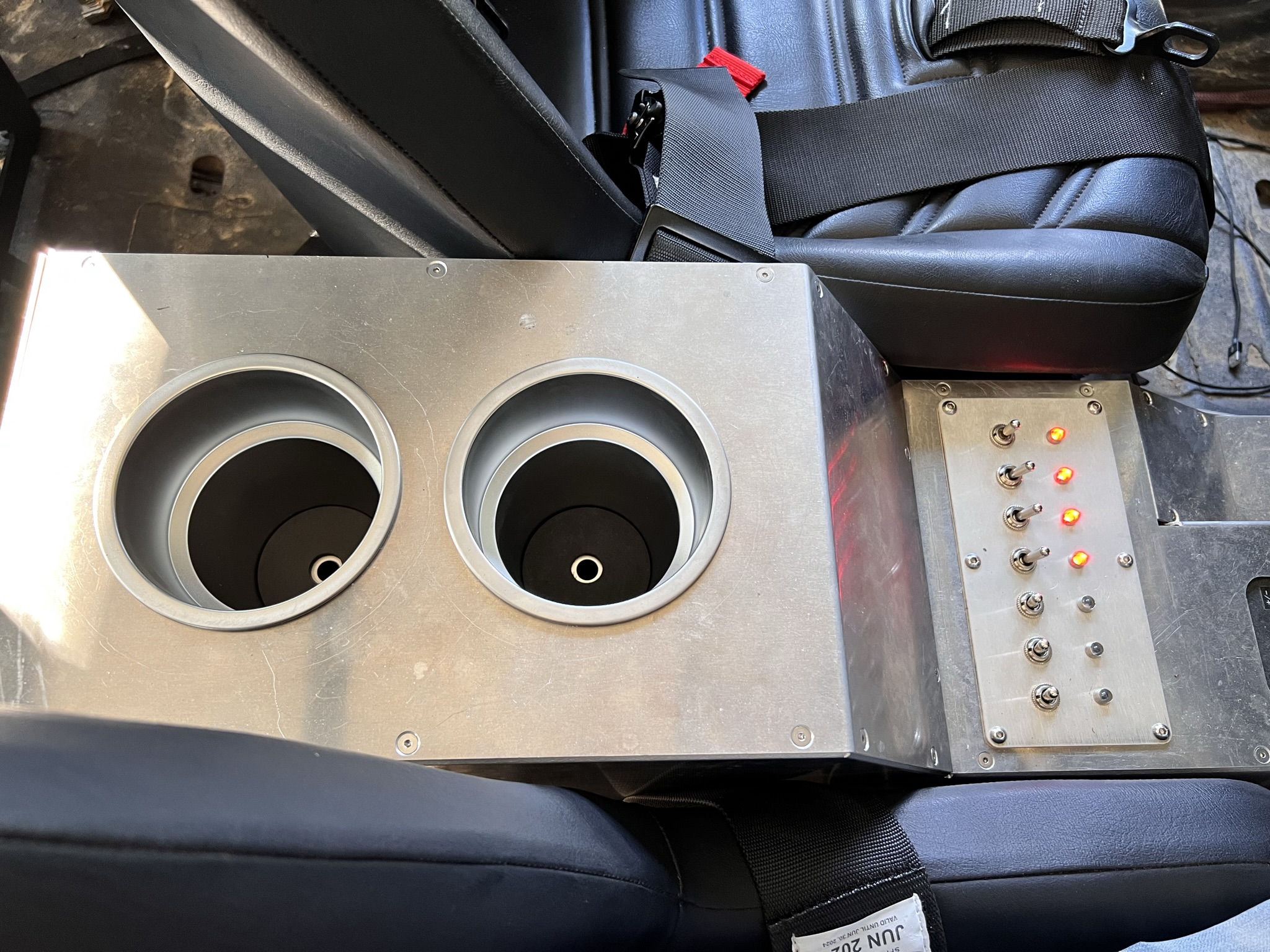 Custom aluminum center console with cup holders and an illuminated switch panel